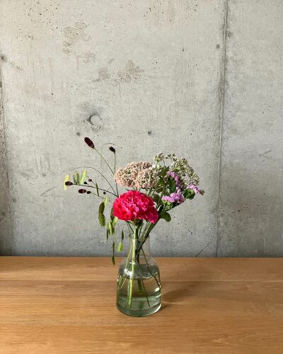 medeluのANYROOMコースのボリュームLite+のお花を緑の透明ガラス花瓶に生けた様子