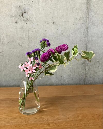 千日紅、スターチスなどのピンク＆パープル系のお花をクリア（透明）の花瓶に生けた様子