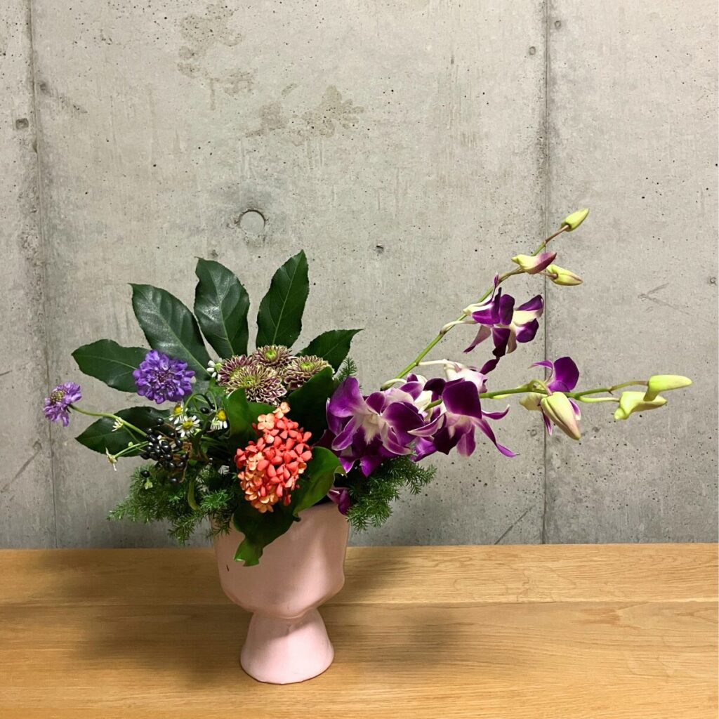 ヤツデ、デンファレとサンタンカ、ティナス、スプレーマムに加え、マトリカリア、サツマスギ、スカビオサを挿した状態