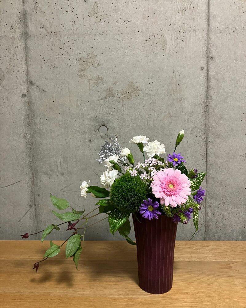 ガーベラ、カーネーション、クレマチスなどを使ったアレンジメント