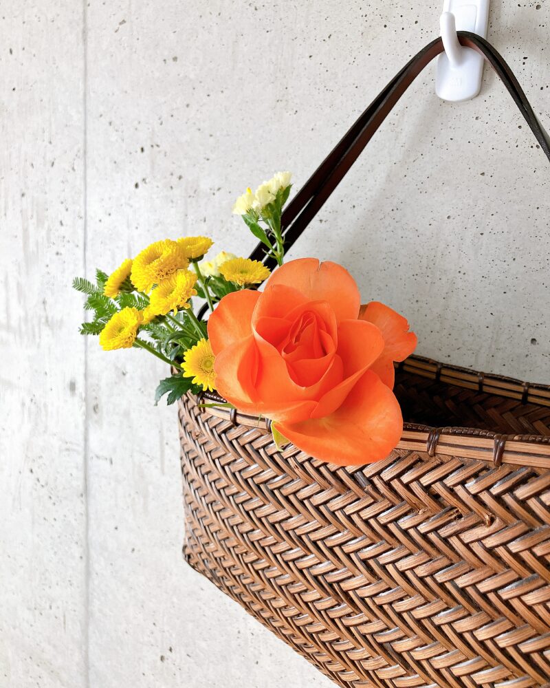ブルーミーから届いたお花を壁掛けのかごバッグに飾っている様子をアップにした写真