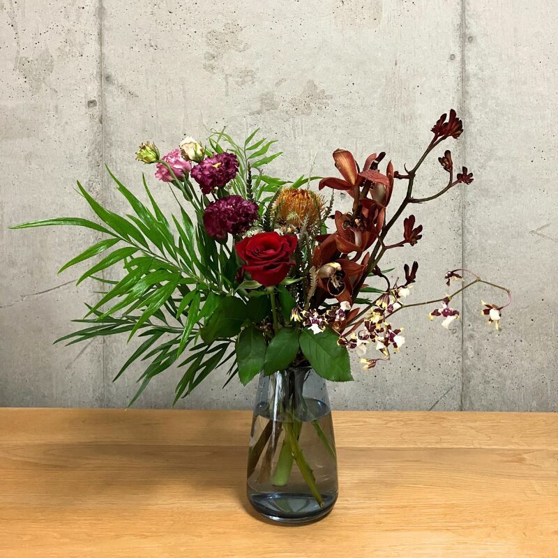 medeluのMODERNコースのボリュームBasicのお花を青の透明ガラス花瓶に生けた様子