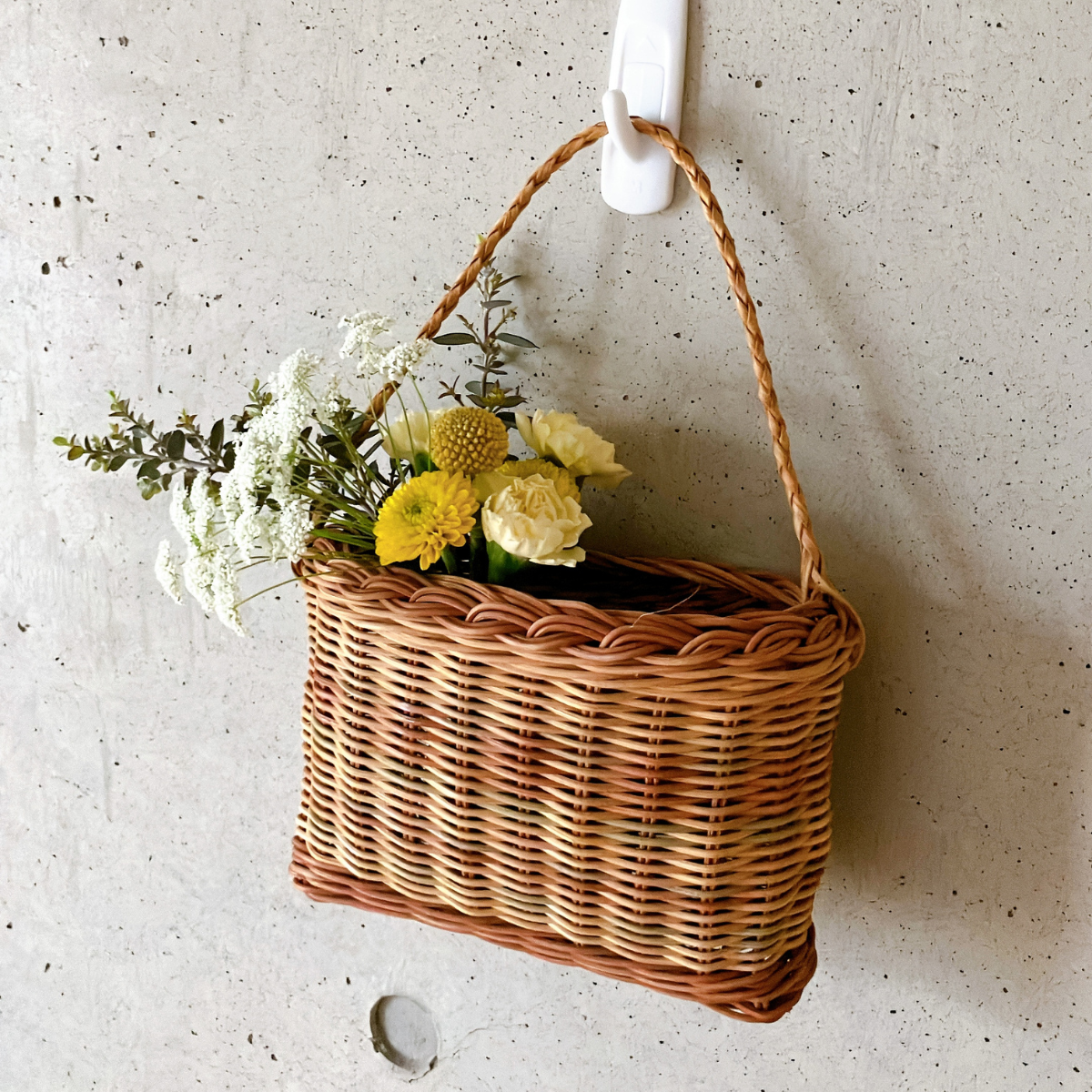 小さいハンギングバスケットにスプレーマムなど定期便の残りの花を生けている様子