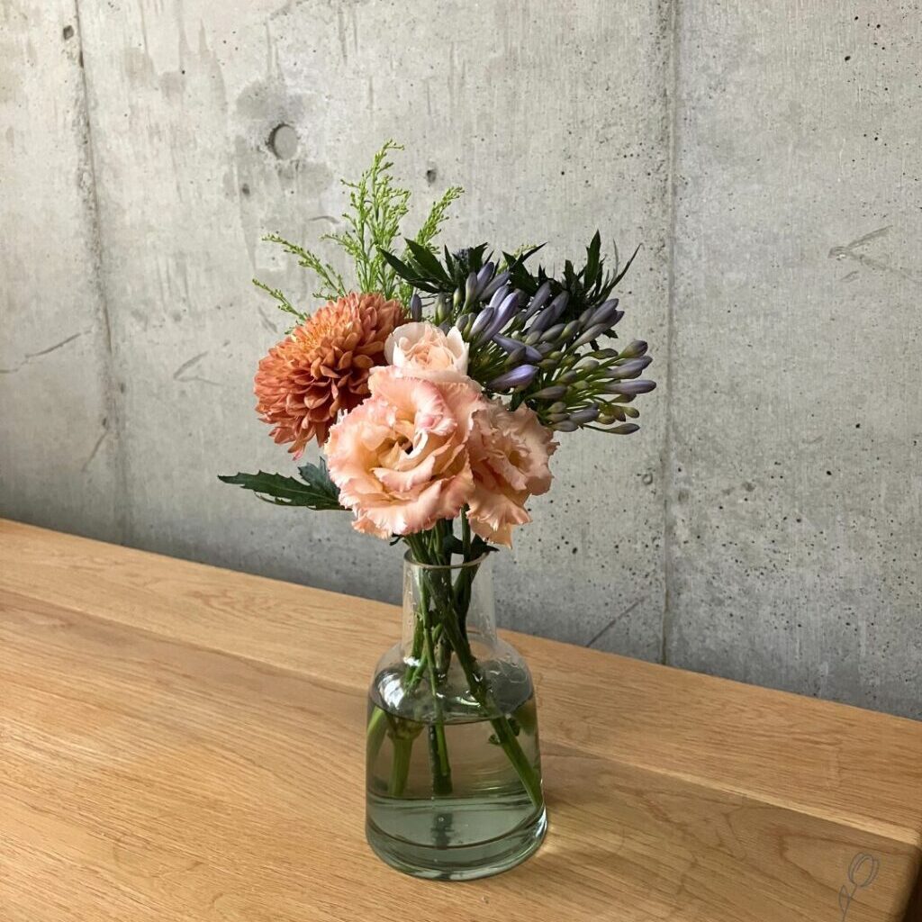 POSH LIVING ガラスボトル グリーンに花の定期便HitoHanaから届いたトルコキキョウ、アガパンサス、マムなどを生けた様子