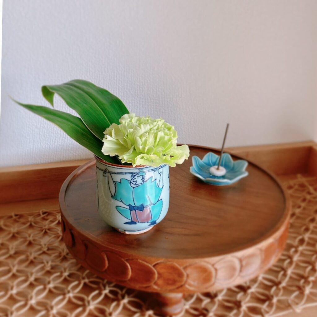 Teacup with a kimono illustration featuring a carnation and a blue bean plate