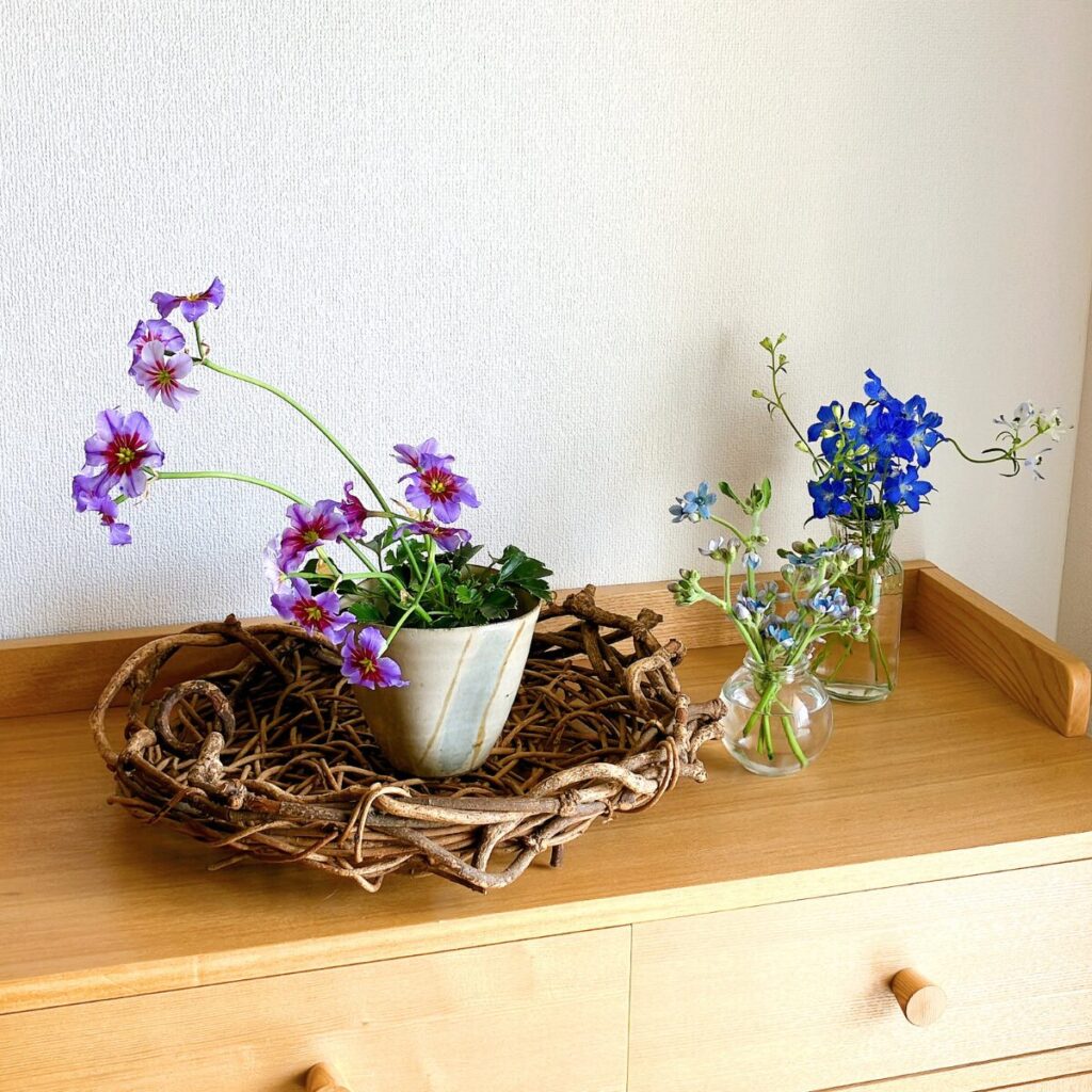 Leucocoryne in a rustic basket styled alongside Blue Star and Delphinium flowers
