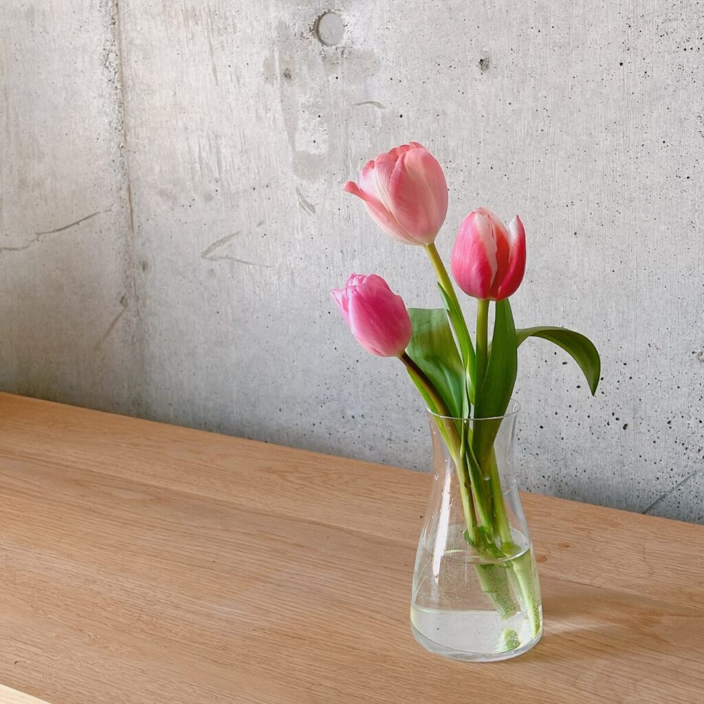 スーパーで購入したピンクのチューリップを花瓶に生けた様子