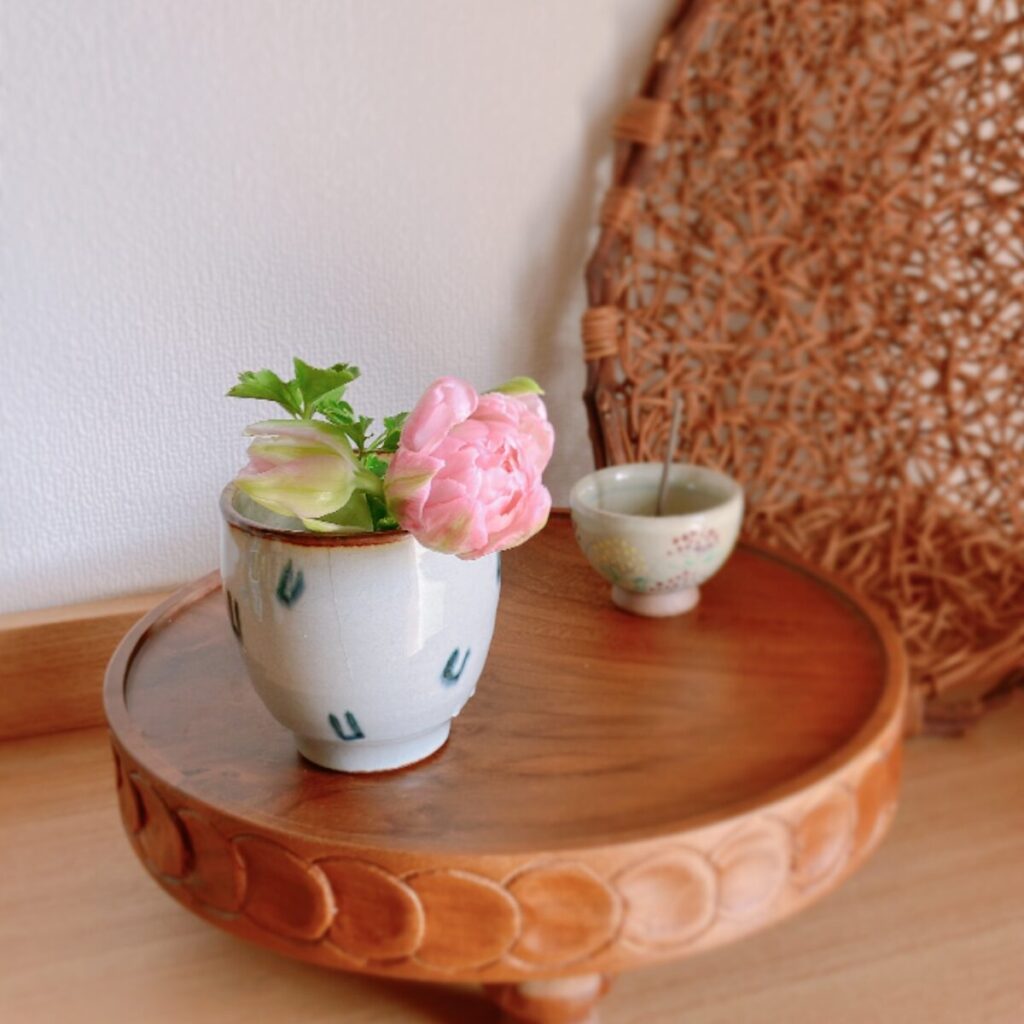 Tulips in a Japanese teacup with incense and a woven basket in the background