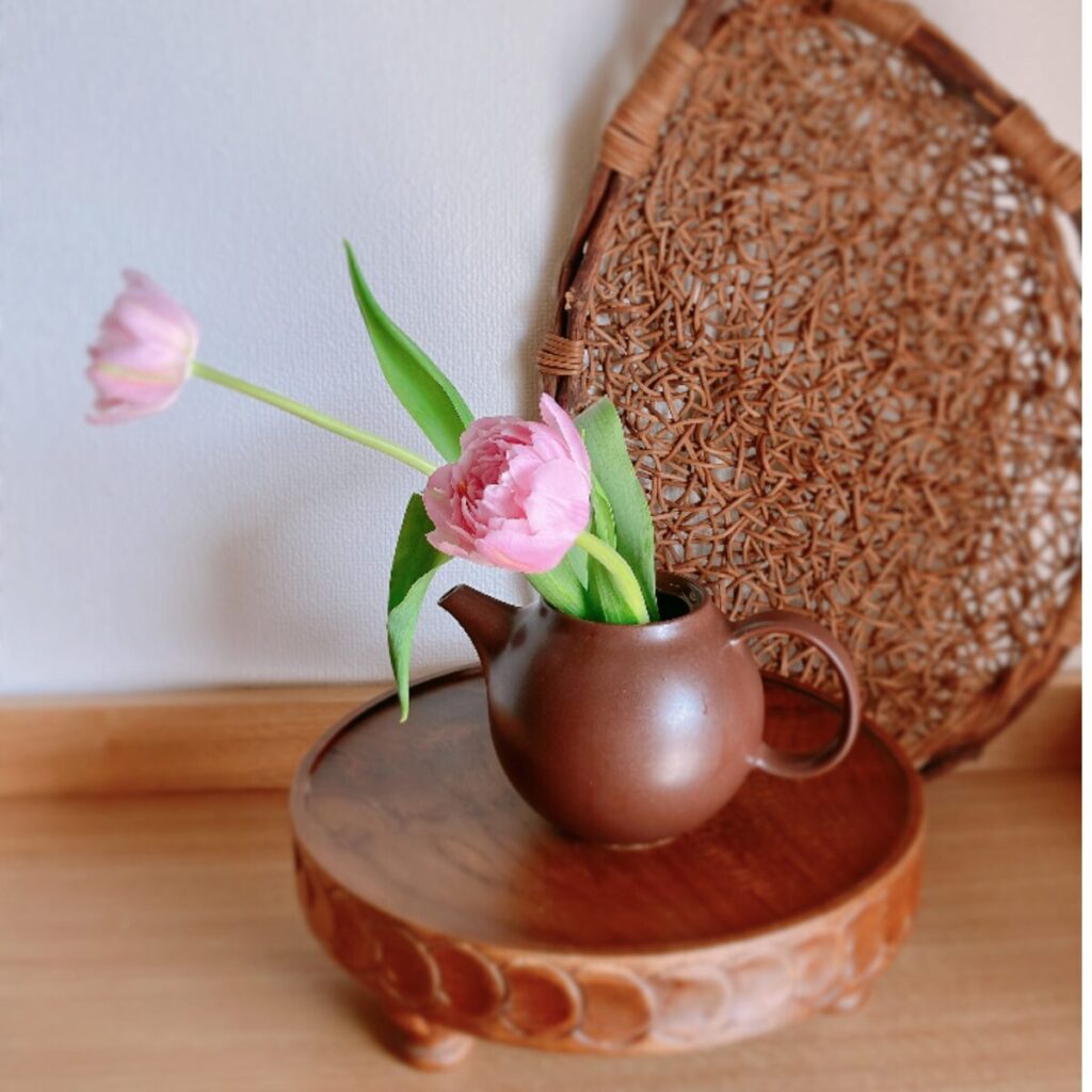 Two tulips arranged in a traditional brown Japanese teapot (Kyusu)