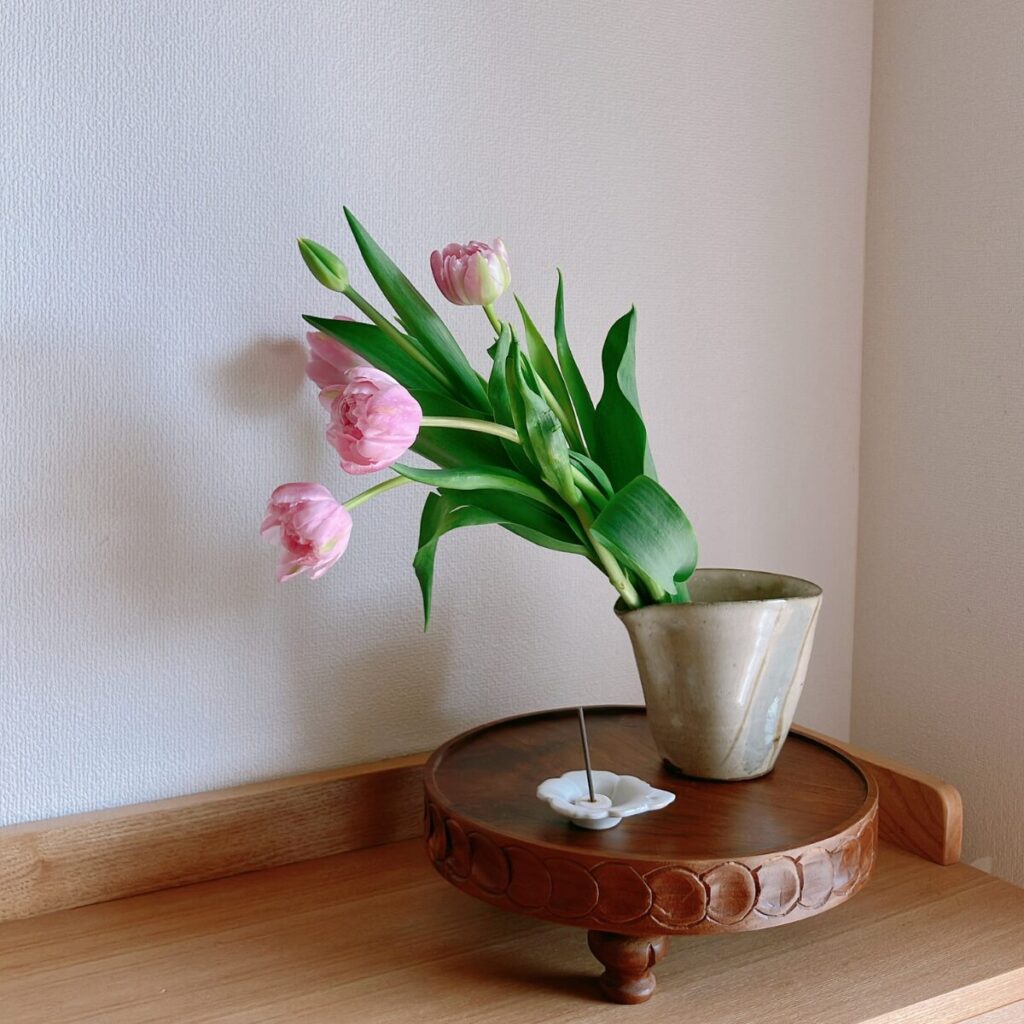 Tall tulips in a soba-tsuyu pitcher with a flower-shaped bean plate in the foreground