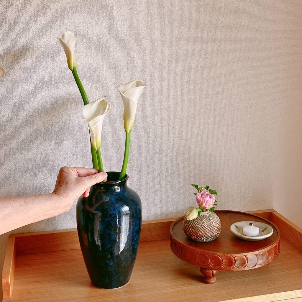 Modern Japandi decor featuring tall calla lilies and tulips on a wooden compote