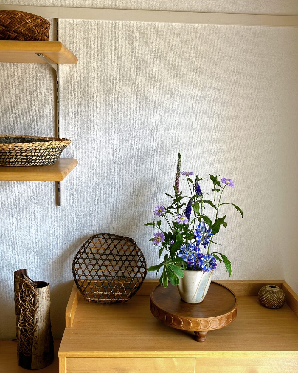 Modern rustic interior styling showing a blue lupine and green flower arrangement in a shelf