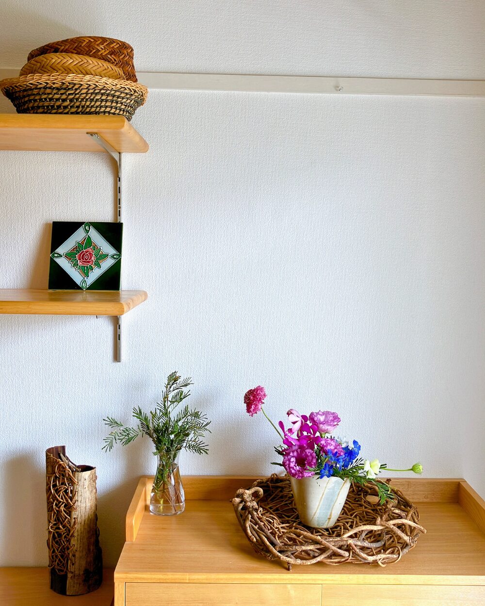 A chic flower arrangement with purple and blue tones styled on a wild grapevine basket