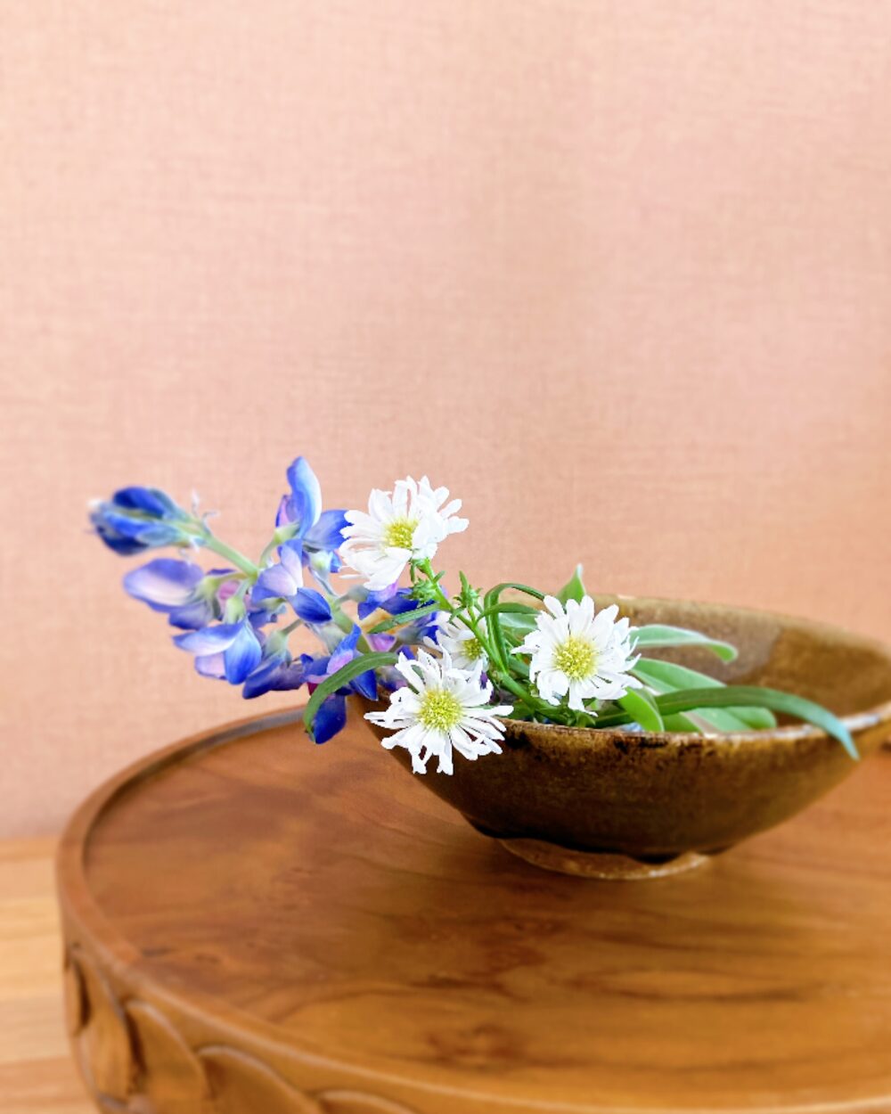 Minimalist flower styling with blue lupinus and small white flowers in a shallow Kasama-yaki dish