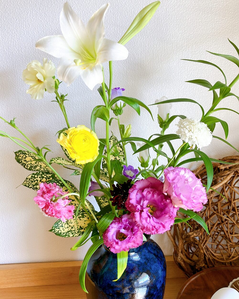 Close-up of Lisianthus and Ranunculus Lux in a traditional Japanese ceramic vase