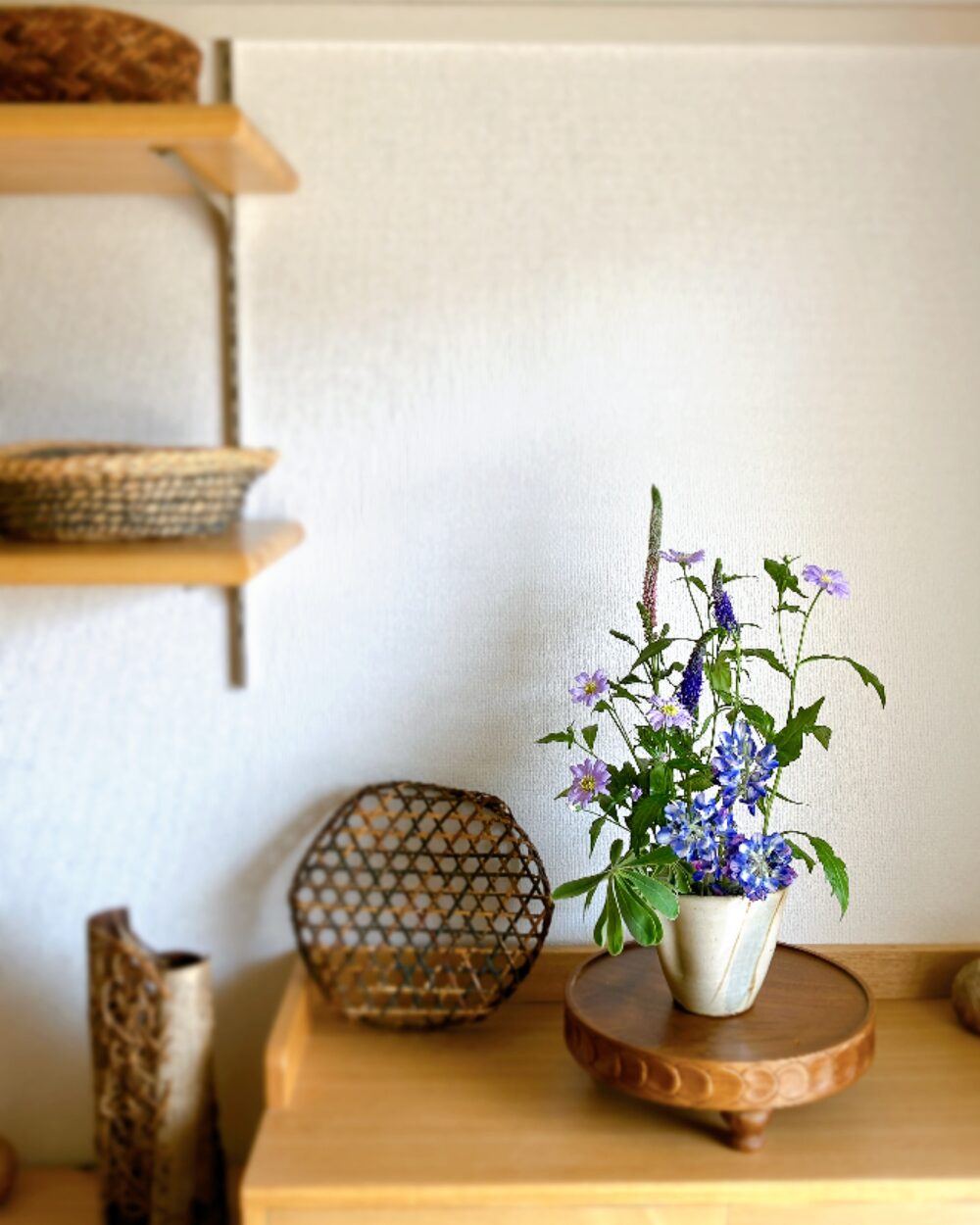 Modern rustic interior styling showing a blue lupine and green flower arrangement in a living room