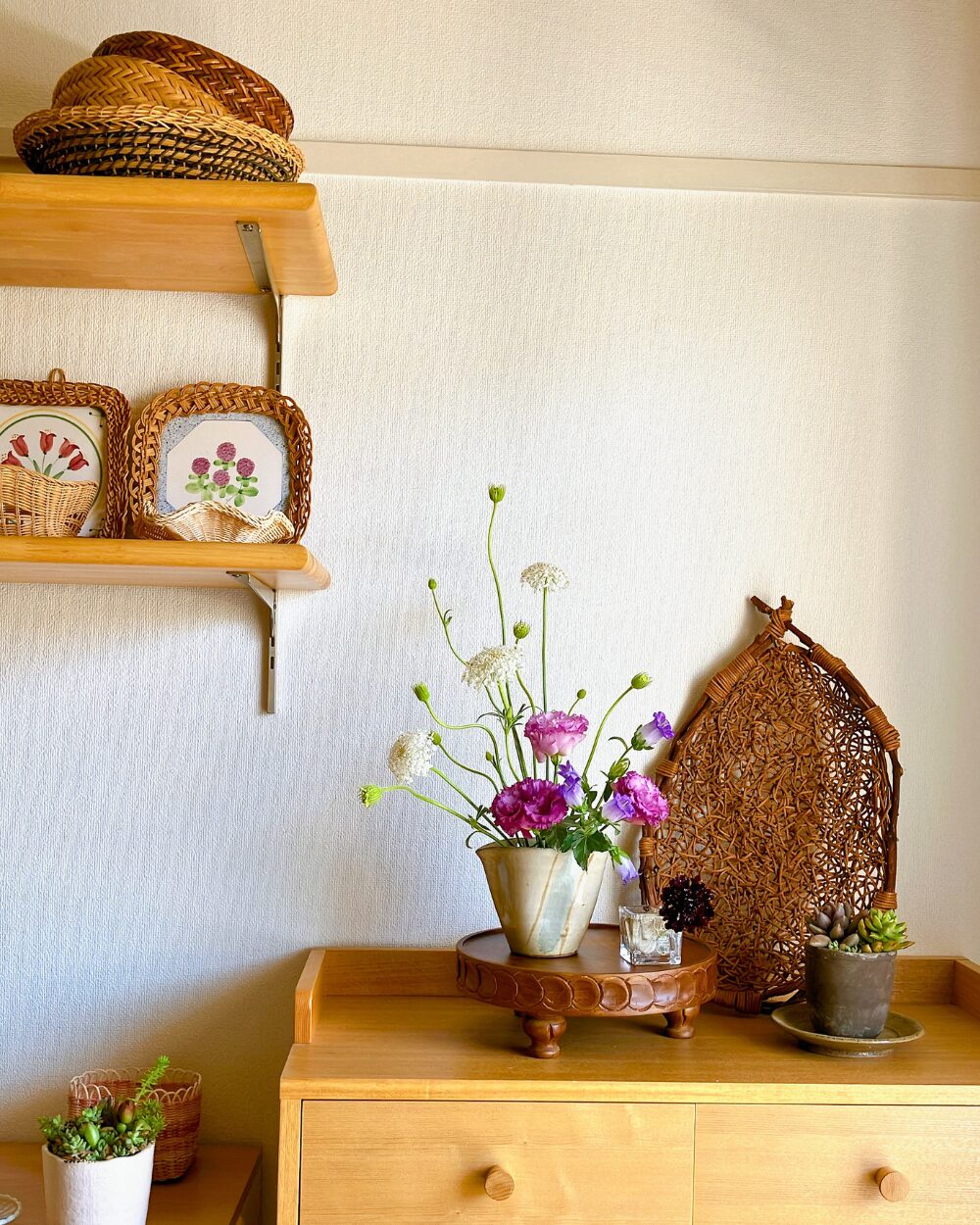 Purple Lisianthus styled on a wooden pedestal compote next to a tiled shelf