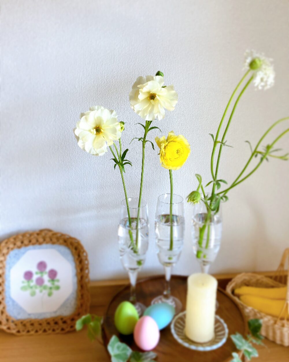 A single stem of glossy Ranunculus Lux in a champagne glass for a simple Easter table