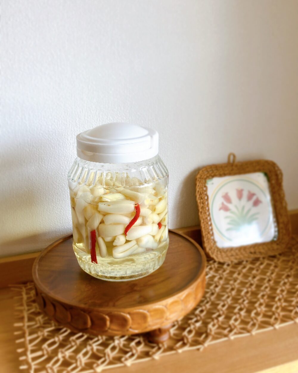 A glass jar of homemade pickled shallots with red chili peppers, the source of inspiration for the styling.