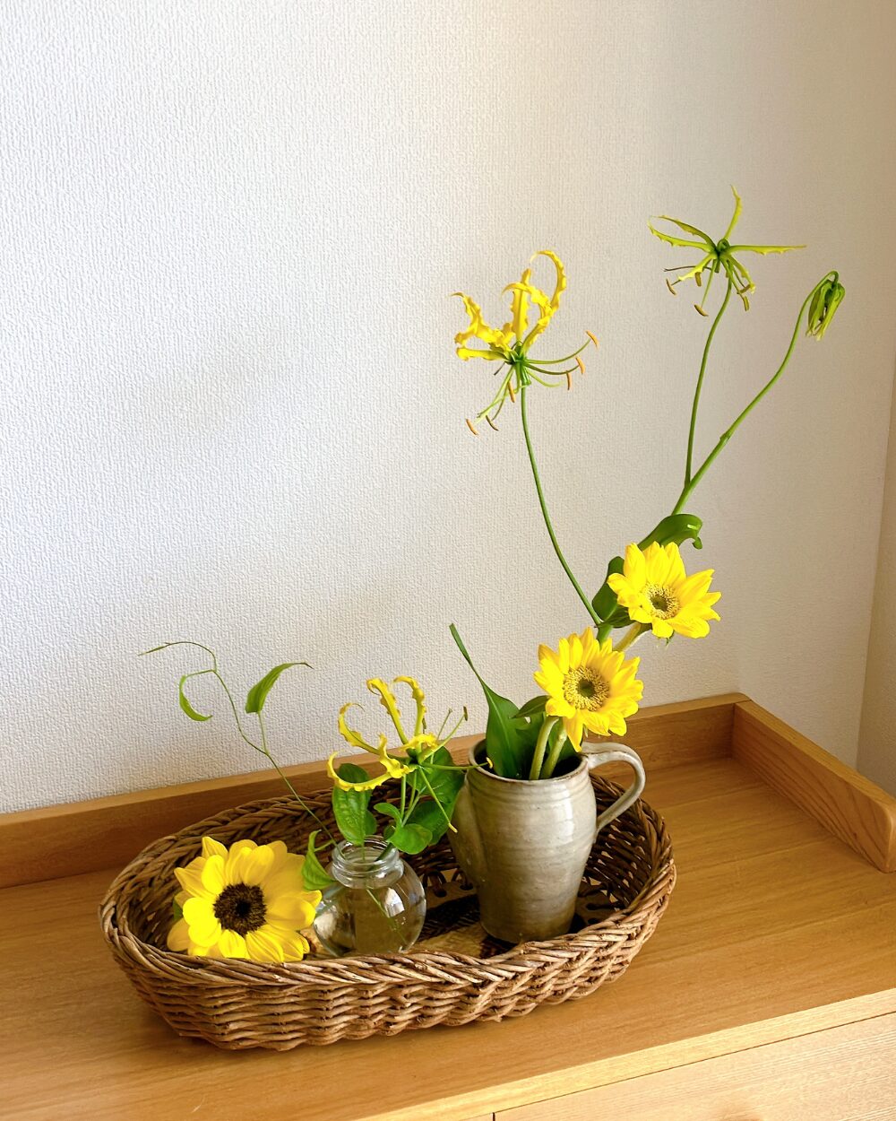 Angled wide shot of the three flower vases styled inside a basket