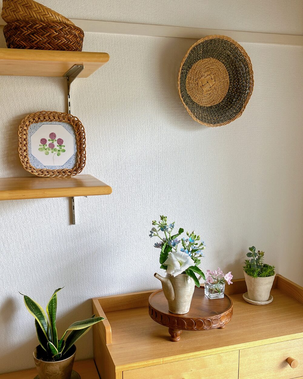 Wide shot of a minimalist flower arrangement on a shelf with a basket