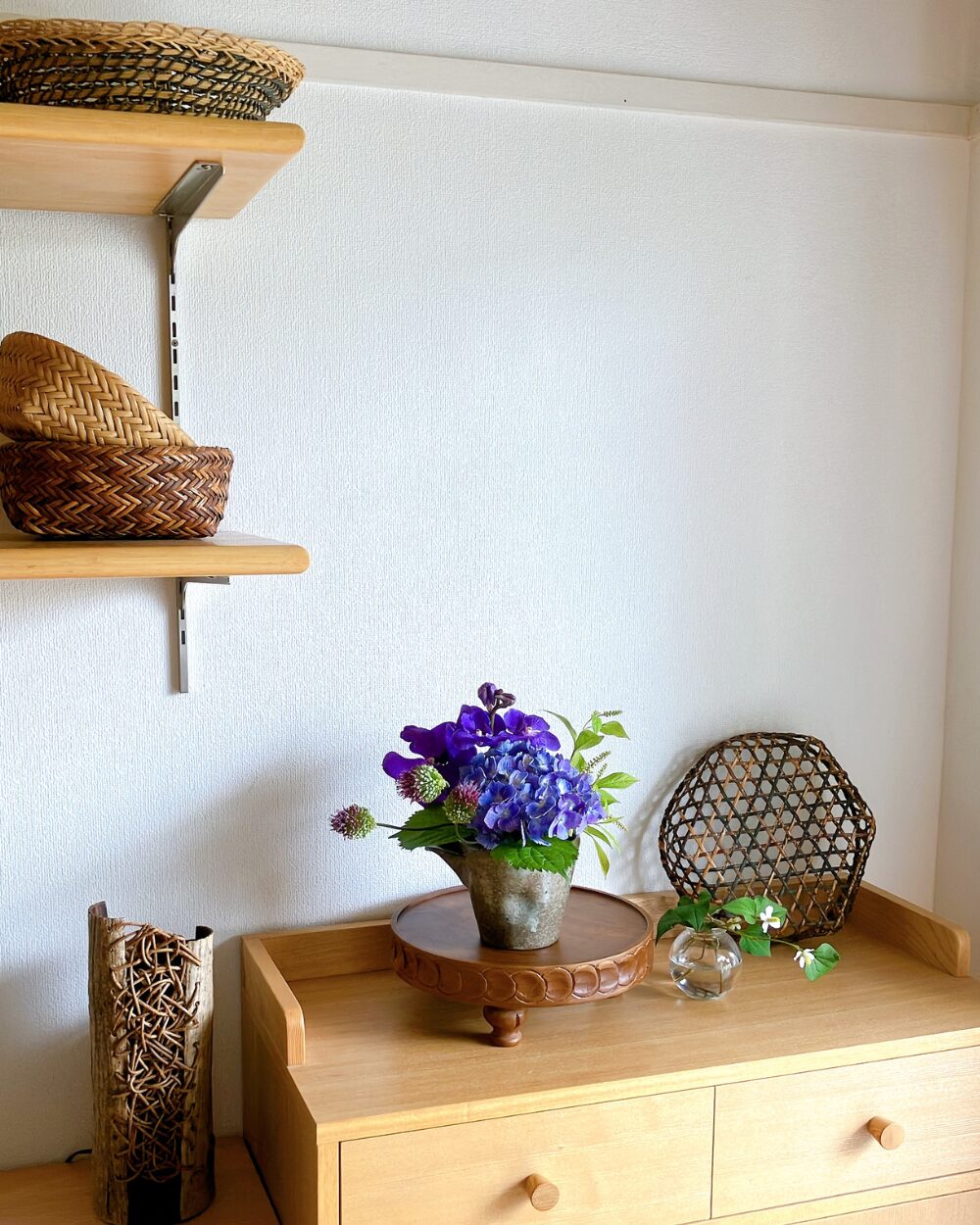 A wide view of the flower arrangement with a basket placed in the background.