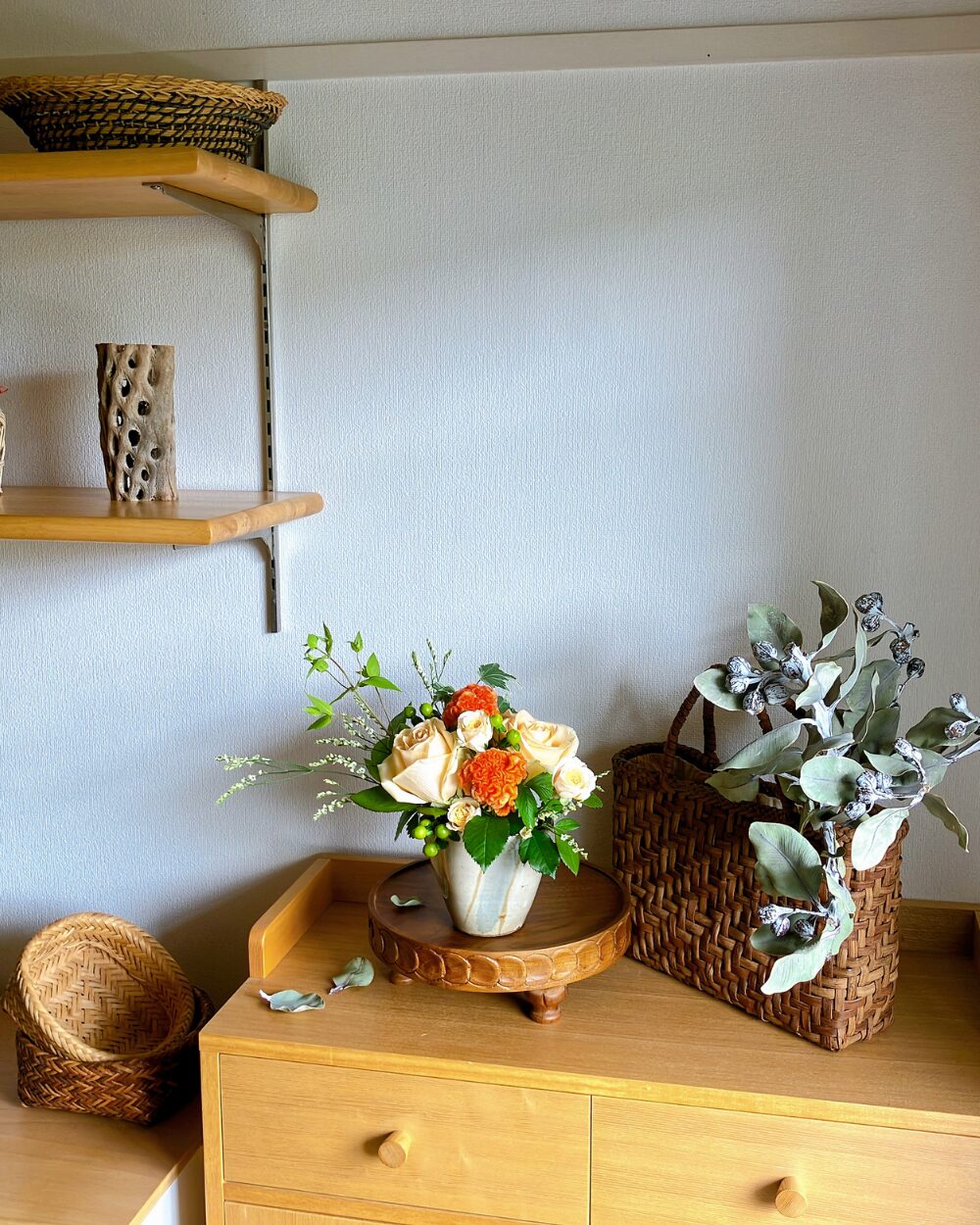A wide view of the living room interior featuring a charming mound of orange roses styled on a shelf, adding a warm color to the room.