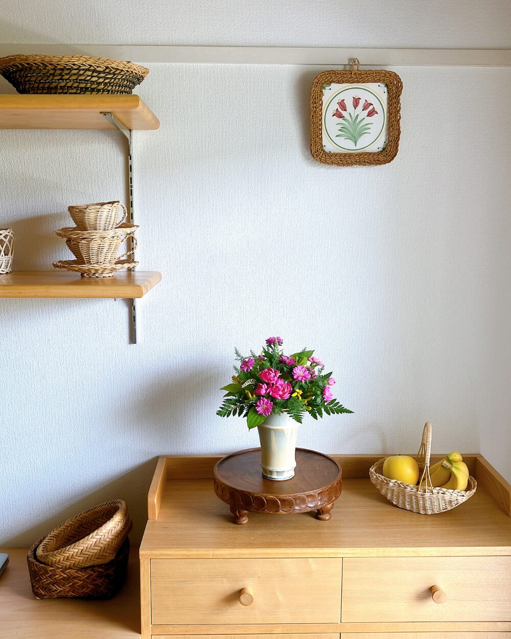 The pink and yellow round flower arrangement displayed inside a room interior.