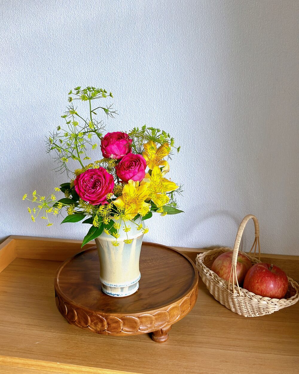 Rounded petals of a deep pink rose in a ceramic vessel.
