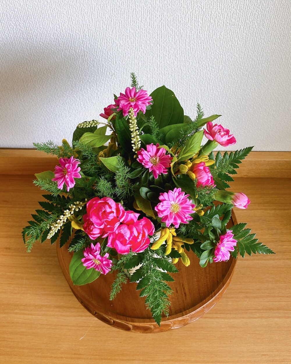 A top-down view of the pink and yellow round flower arrangement showing the depth.