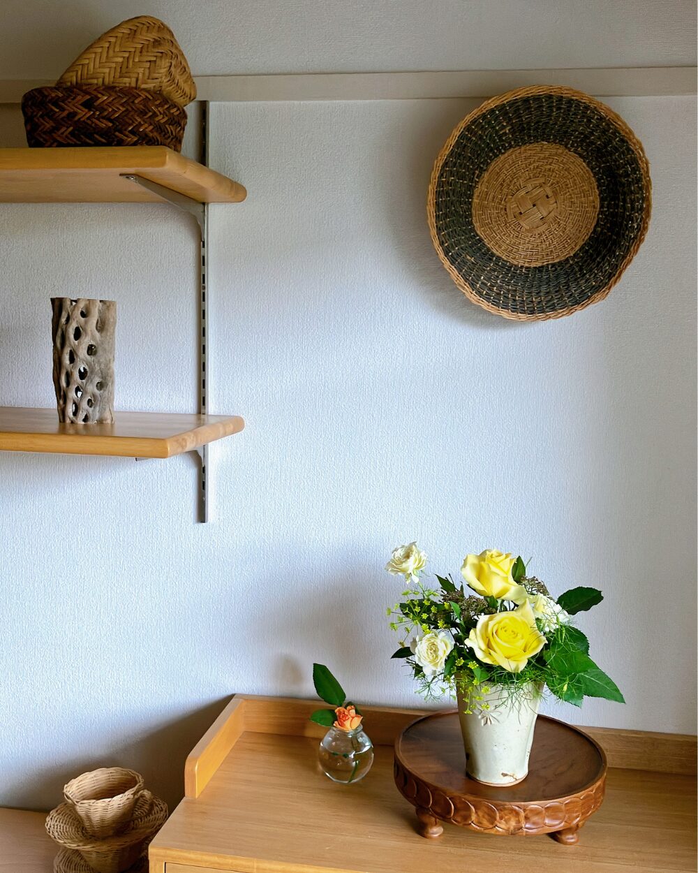 Yellow roses arranged with fennel and shimotsuke leaves on a wooden shelf