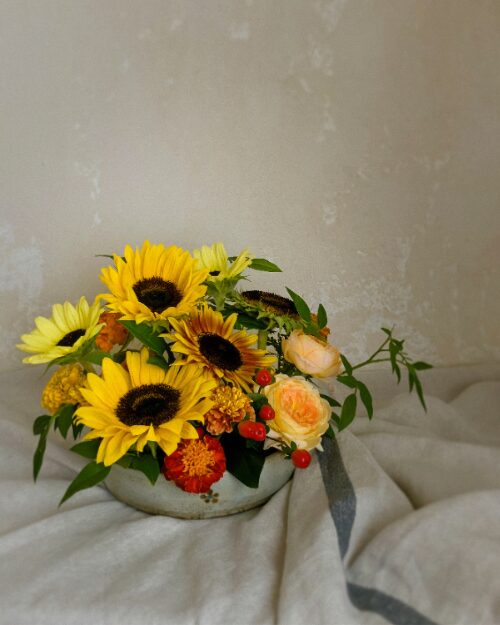A fine-art photo preview of the abundant low sunflower and marigold dish captured dramatically against a dark background.