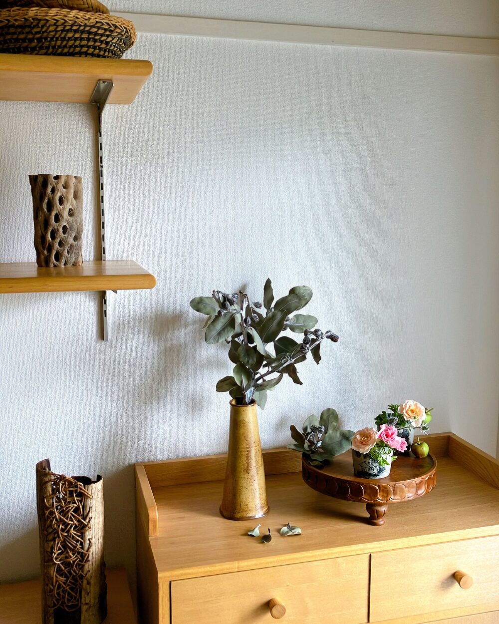 A long shot of the wood compote styling with a soba choko cup and dried tetragonanuts framing the setting on a table.