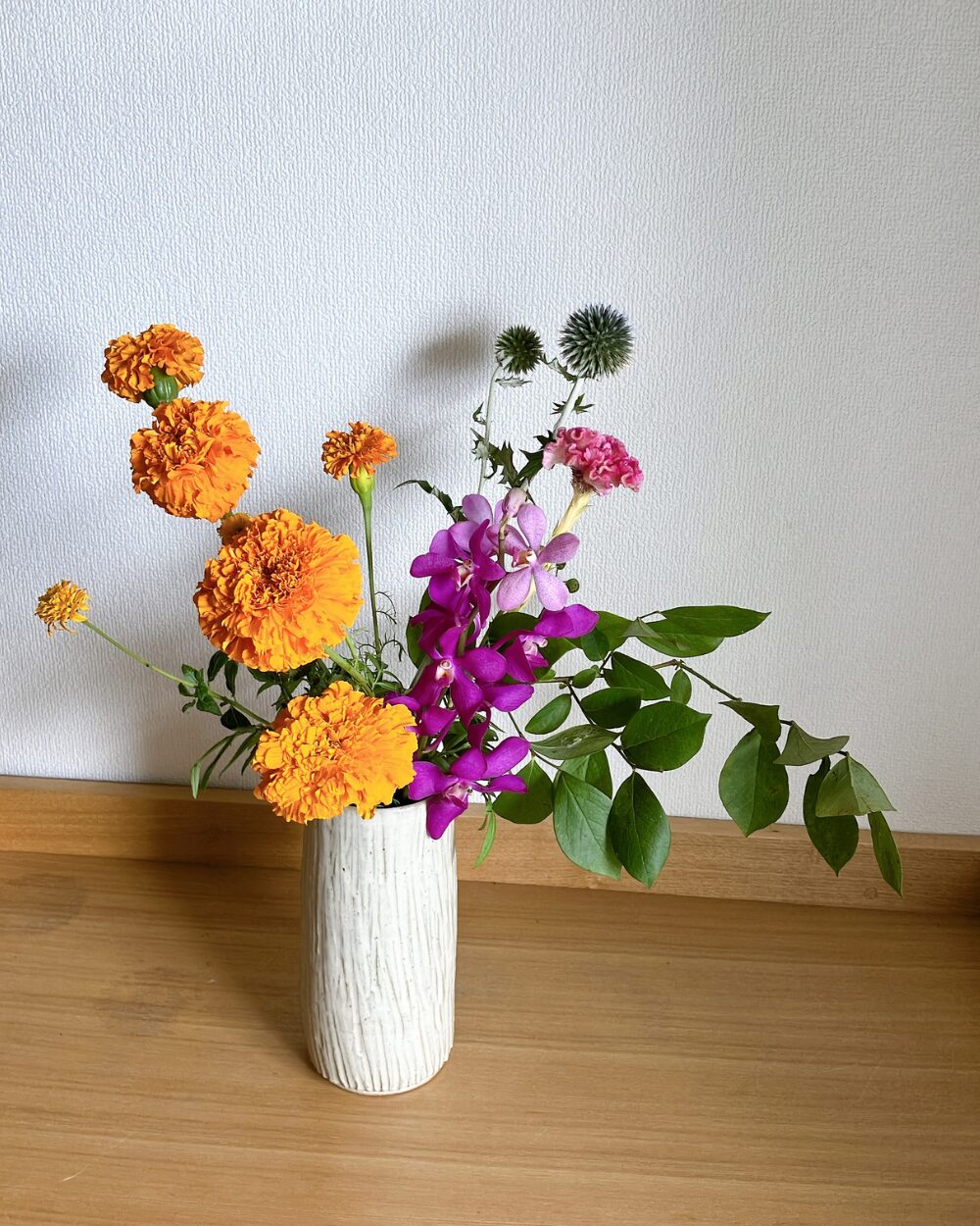 Delivered flowers including marigolds, mokara, and cockscomb before arrangement.