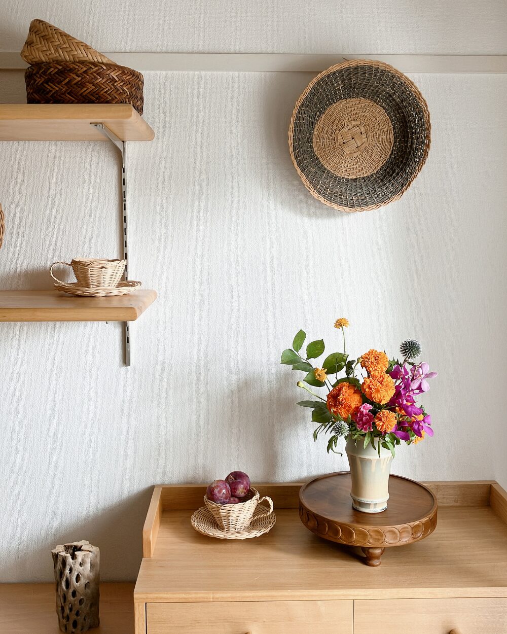 A wide interior shot showing a quiet corner of the room with the flower display on the shelf.