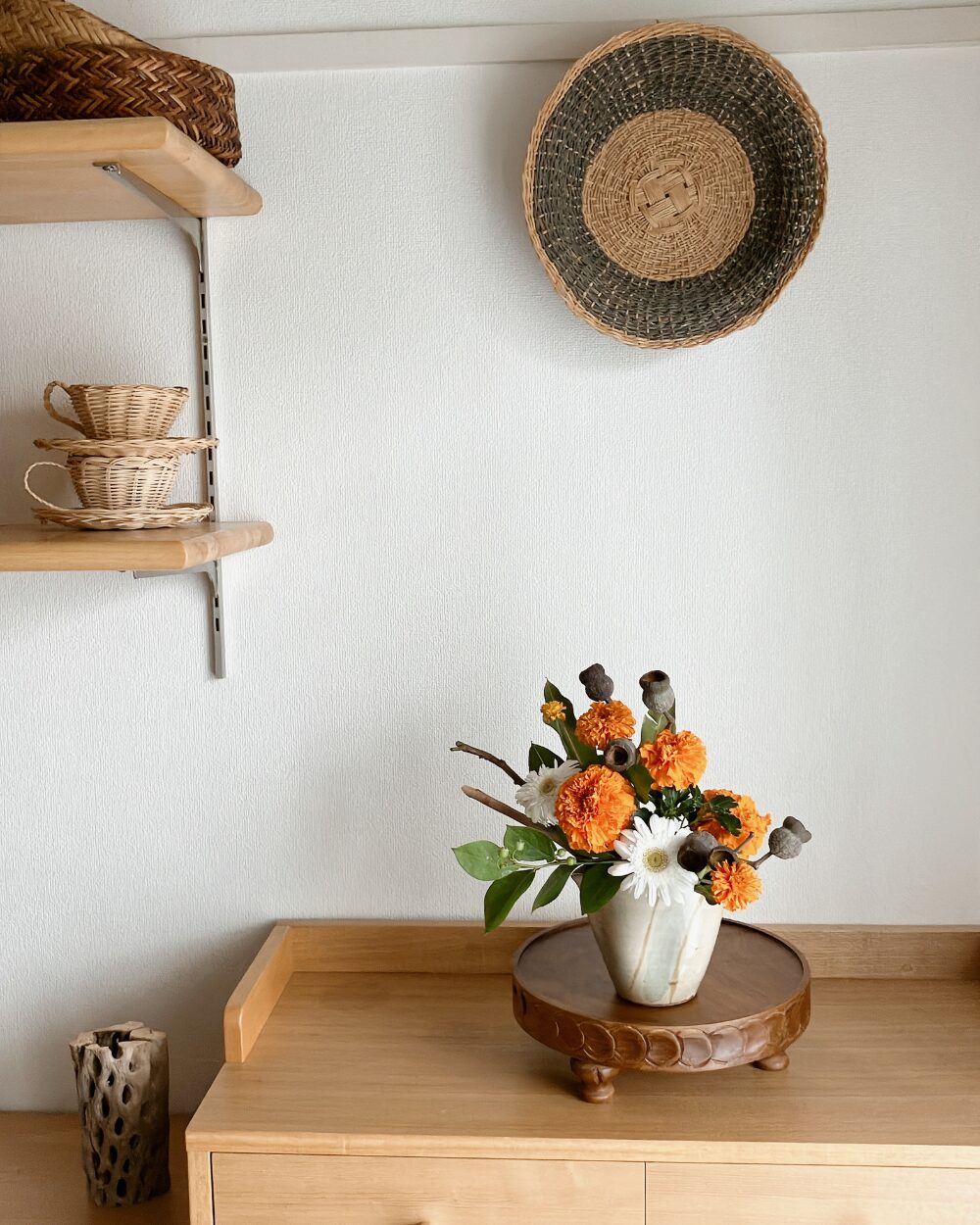 A pulled-back view showing the entire shelf display with the flower arrangement sitting in the room.