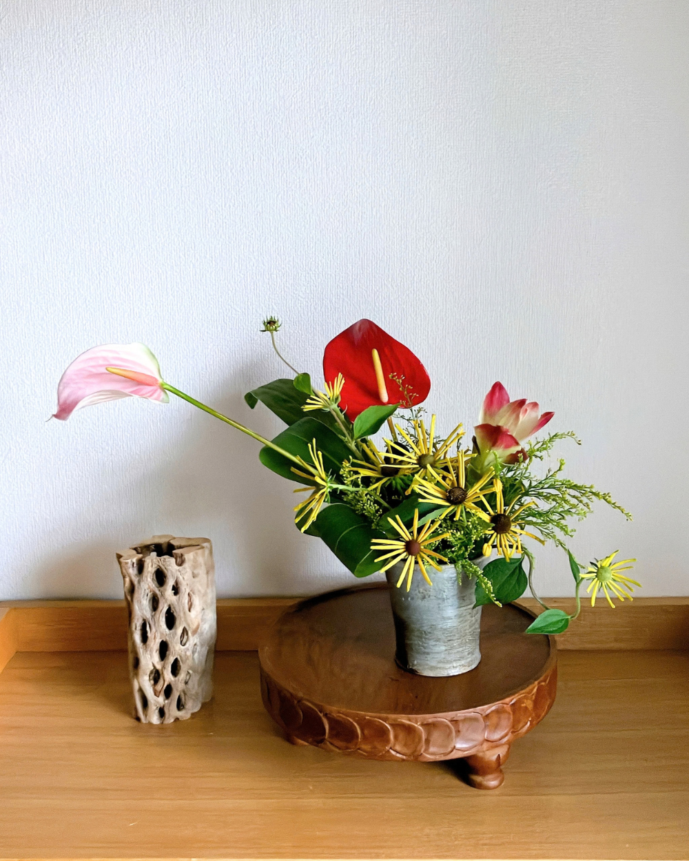 Anthurium paired with bright yellow rudbeckia and curcuma in a Japanese ceramic
