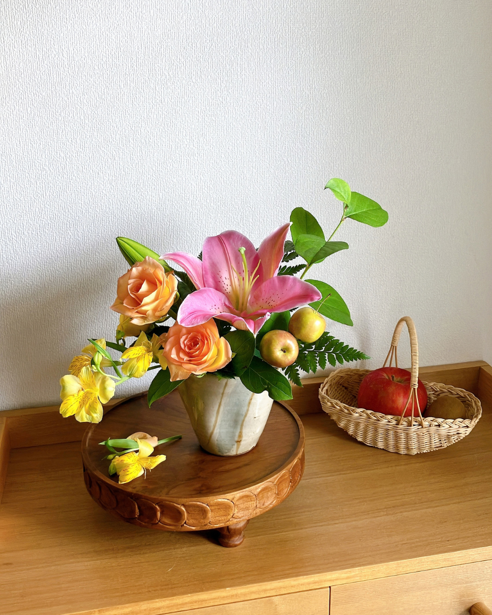 Front view of pink, orange, and yellow flowers in a pale glazed Japanese ceramic.