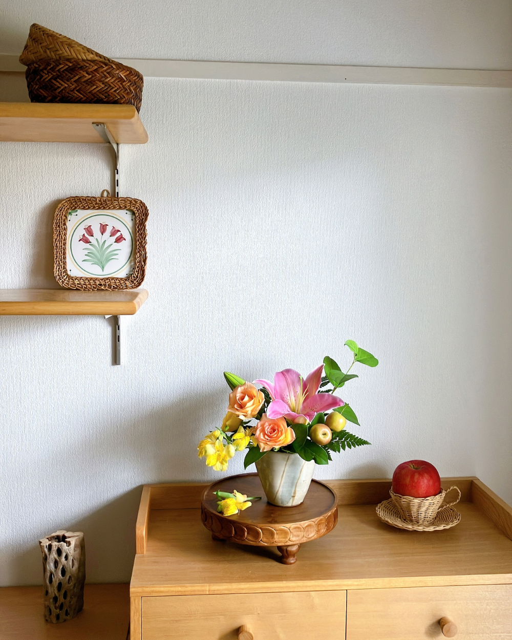 Wide shot of pink lily, orange rose, and yellow alstroemeria arranged together in a light blue-grey ceramic Katakuchi.