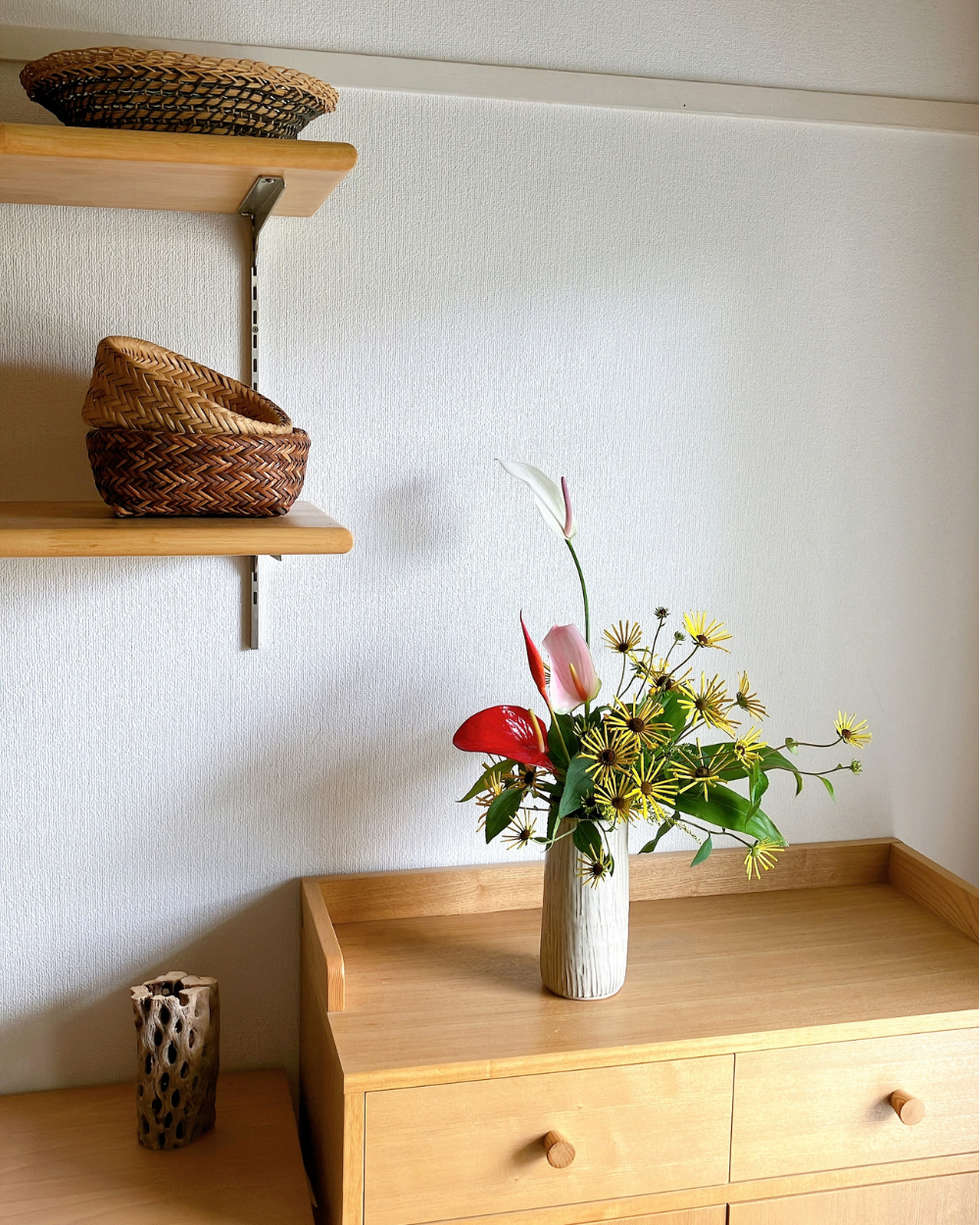 Taller Kasama ware ceramic vase arrangement with vibrant rudbeckia and anthurium